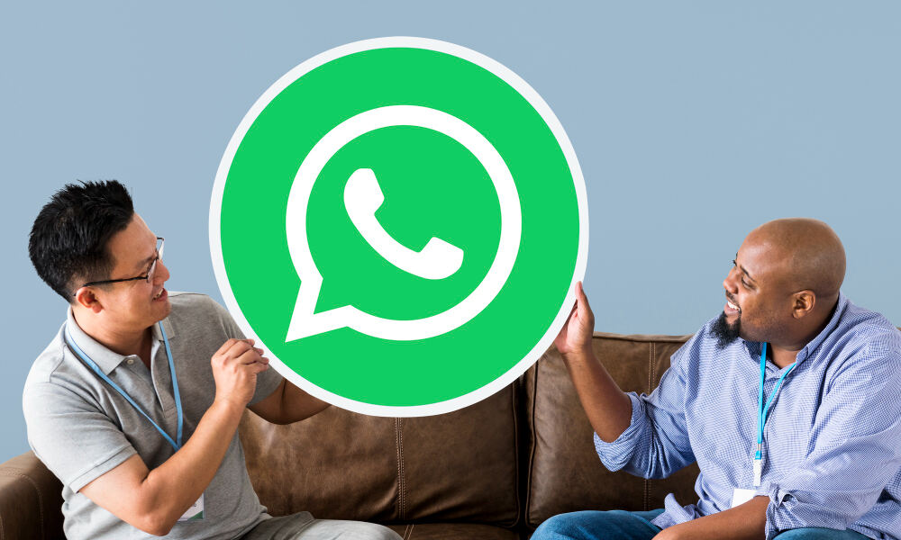 Two guys showing WhatsApp logo 